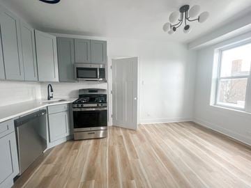 Chicago apartment for rent - A kitchen with a stove top oven and a microwave above the stove.