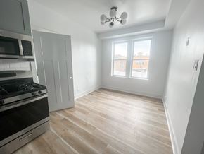 Chicago apartment for rent - A kitchen with a stove, microwave, and a window.