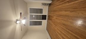 Chicago apartment for rent - A ceiling fan with lights is on in a room with wood paneling.
