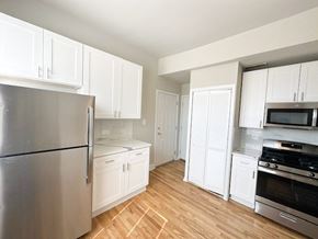Chicago apartment for rent - A kitchen with white cabinets and a stainless steel refrigerator.