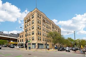 Chicago apartment for rent - A large tan building with a flat roof and a street in front of it.