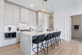 Chicago apartment for rent - A modern kitchen with a marble island and black barstools.