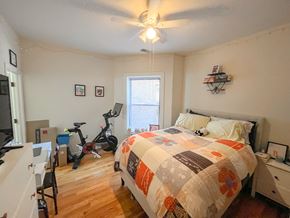 Chicago apartment for rent - a bedroom with a bed and an exercise bike in the corner
