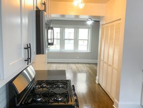 Chicago apartment for rent - A kitchen with a stove top oven and a window.