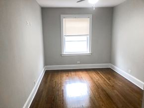 Chicago apartment for rent - A room with a window and wooden floors.