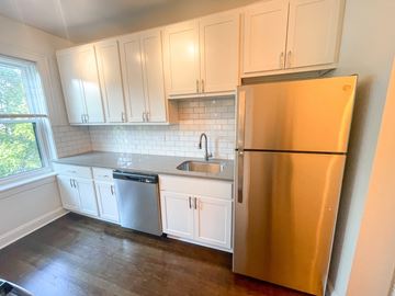 Chicago apartment for rent - A kitchen with white cabinets and a stainless steel refrigerator.
