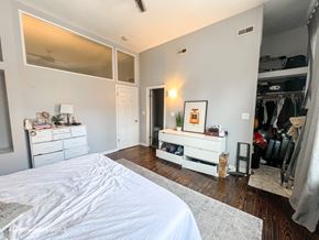 Chicago apartment for rent - A bedroom with a large bed and a white dresser.