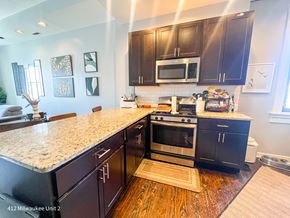 Chicago apartment for rent - A kitchen with black cabinets and a granite countertop.