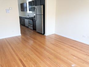 Chicago apartment for rent - a kitchen and living room with wood floors and a refrigerator