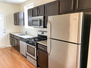 Chicago apartment for rent - a kitchen with stainless steel appliances and black cabinets