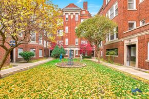 Chicago apartment for rent - a courtyard between two brick buildings with a fountain in the middle