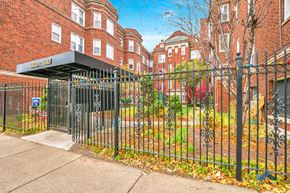 Chicago apartment for rent - a wrought iron fence in front of a yard behind a apartment building