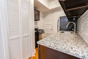 Chicago apartment for rent - A kitchen with a granite countertop and white cabinets.