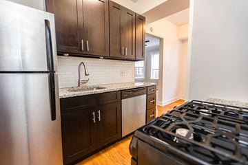 Chicago apartment for rent - A modern kitchen with a stainless steel refrigerator and black cabinets.