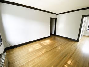 Chicago apartment for rent - A room with wooden floors and white walls.