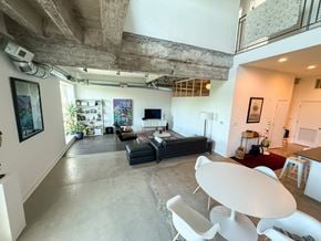 Chicago apartment for rent - A living room with a black couch and a white chair.