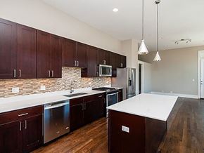Chicago apartment for rent - A kitchen with dark wood cabinets and a white counter top.