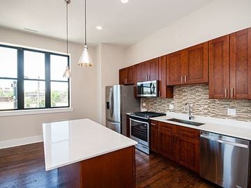 Chicago apartment for rent - A kitchen with wooden cabinets and stainless steel appliances.