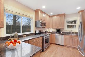 Winnetka townhouse for rent - A kitchen with wooden cabinets and a granite countertop.