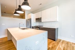 Chicago apartment for rent - a kitchen with white cabinets and a large counter top