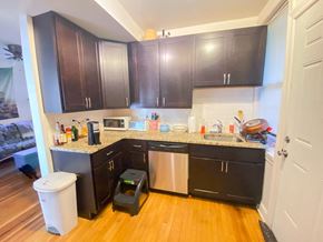 Chicago apartment for rent - a small kitchen with black cabinets and a counter top