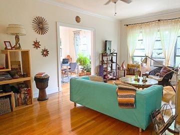 Chicago apartment for rent - A living room with a green couch and a wooden floor.