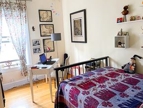 Chicago apartment for rent - A bedroom with a bed, desk, chair, and pictures on the wall.
