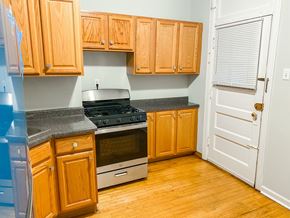 Chicago apartment for rent - A kitchen with wooden cabinets and a stove top oven.