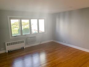 Chicago apartment for rent - an empty living room with a wooden floor and a window
