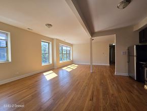 Chicago apartment for rent - an empty living room with hard wood floors and windows