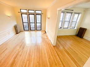 Chicago apartment for rent - A room with wooden floors and a large window.