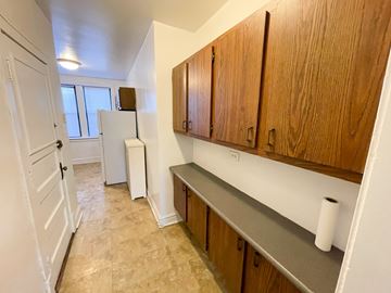 Chicago apartment for rent - A kitchen with wooden cabinets and a white fridge.