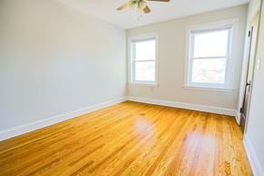 Chicago apartment for rent - A room with wooden floors and two windows.