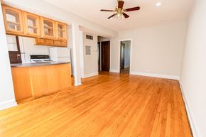 Chicago apartment for rent - A room with wooden floors and a ceiling fan.
