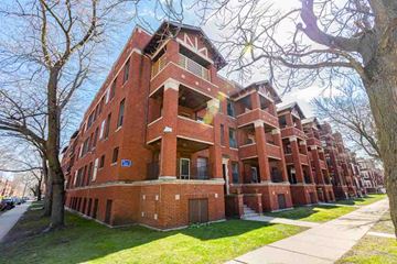 Chicago apartment for rent - A red brick apartment building with a tree in front.
