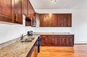 Chicago apartment for rent - a kitchen with wooden cabinets and granite counter tops and a sink