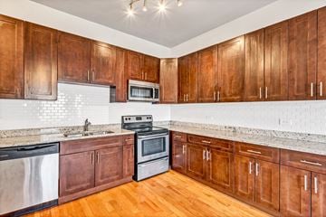 Chicago apartment for rent - a kitchen with wooden cabinets and stainless steel appliances