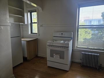 Chicago apartment for rent - A white oven and stove in a kitchen with wood floors and white walls.