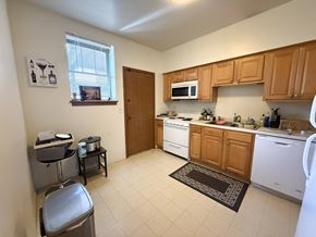 Chicago apartment for rent - A kitchen with white appliances and wooden cabinets.