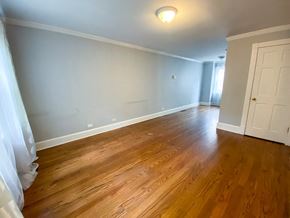 Chicago triplex for rent - a living room with wooden floors and a white door