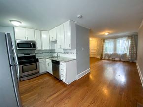 Chicago triplex for rent - an empty kitchen with white cabinets and stainless steel appliances