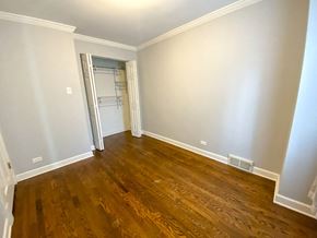 Chicago triplex for rent - a empty living room with wooden floors and a closet