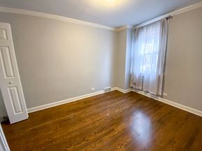Chicago triplex for rent - an empty living room with wood floors and a window