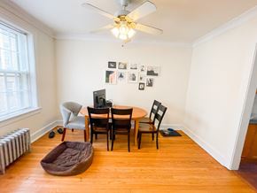 Evanston apartment for rent - A room with a table, chairs, a dog bed, and pictures on the wall.