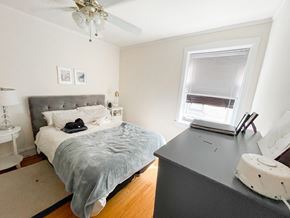 Evanston apartment for rent - A bedroom with a bed, nightstand, and window.