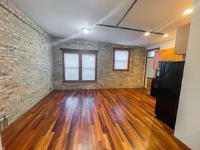Evanston apartment for rent - A room with wooden floors and a brick wall.