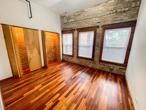 Evanston apartment for rent - A room with wooden floors and a brick wall.