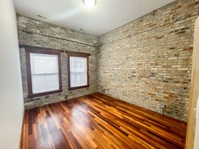 Evanston apartment for rent - A room with wooden floors and a brick wall.