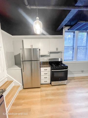 Chicago apartment for rent - a kitchen with white cabinets and a stainless steel refrigerator