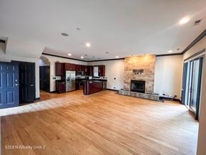 Chicago apartment for rent - an empty living room with a fireplace and a kitchen